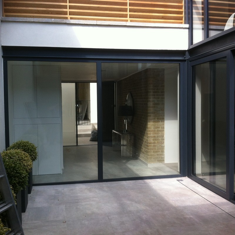 Floor-to-ceiling sliding doors opening to courtyard in Caterham