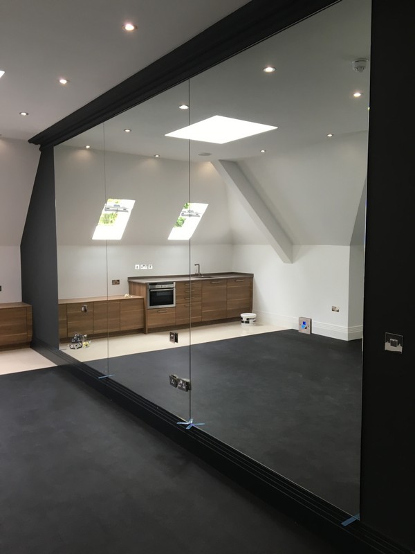 Frameless glass partition in loft conversion by Caterham glaziers