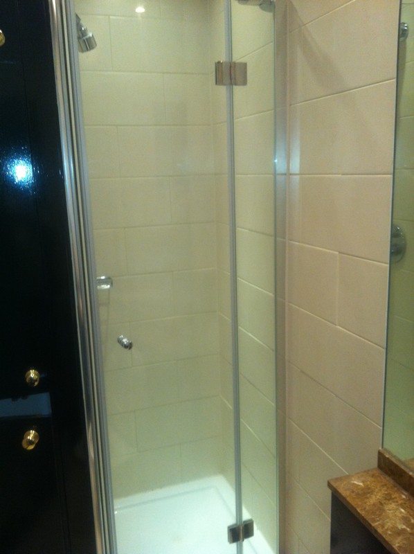 Frameless glass shower enclosure with chrome fittings in Caterham